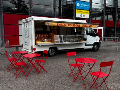 Le camion Buena Aventura installé devant le parc des expositions d’Alpexpo à Grenoble, comptoir ouvert et terrasse de tables rouges dressée.