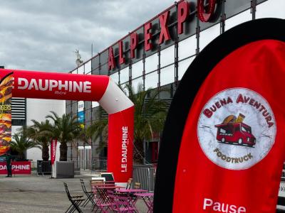 L’oriflamme Buena Aventura « Pause gourmande, foodtruck savoureux » dressée devant le parc des expositions Alpexpo à Grenoble, sous l’arche gonflable du Dauphiné Libéré.